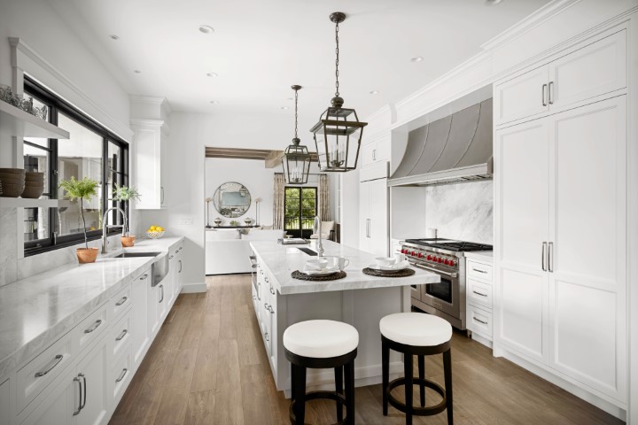 a clean modern kitchen with stainless steel appliances, white countertops, and wooden floors
